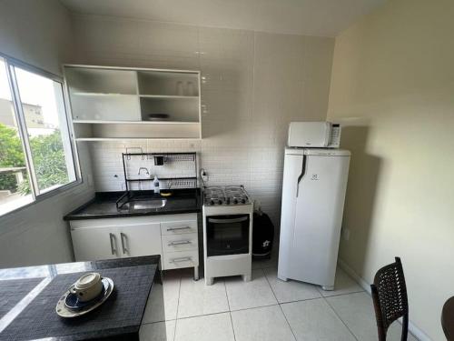 uma pequena cozinha com um frigorífico e um fogão em 303-Apartamento Próximo ao Shopping Vila Velha em Vila Velha