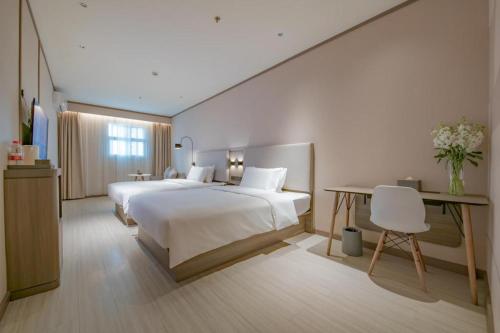 سرير أو أسرّة في غرفة في Hanting Hotel Chengdu Yipintianxia Metro Station