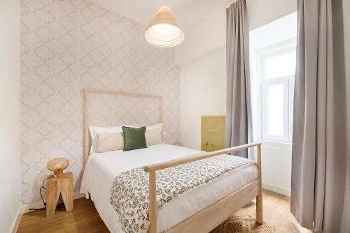 ein Schlafzimmer mit einem Bett mit einer weißen Tagesdecke in der Unterkunft Rua Augusta Dream Apartment in Lissabon