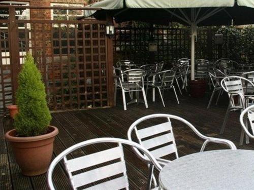 un patio al aire libre con mesas y sillas y una maceta en The Dukeries Lodge, en Edwinstowe