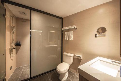 y baño con aseo, lavabo y ducha. en Hanting Hotel Shenyang Nanta Shoe Market, en Shenyang