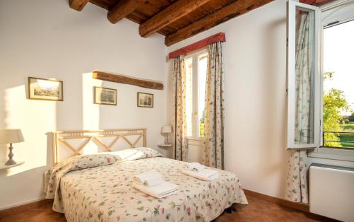 een slaapkamer met een bed en een groot raam bij Agriturismo Sesta Presa in Caorle