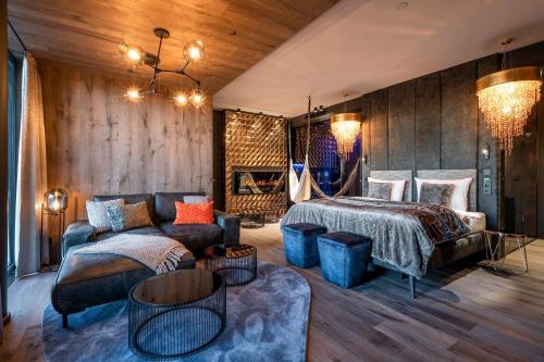 a bedroom with a bed and a couch at Hüttenhof - Wellnesshotel & Luxus-Bergchalets - Adults only in Grainet