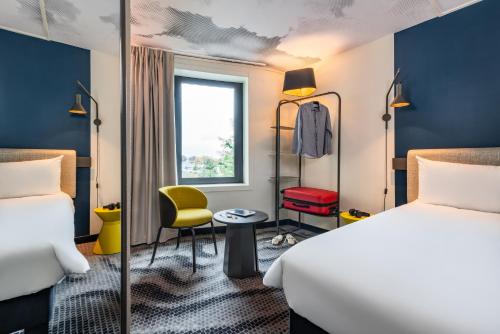 um quarto de hotel com duas camas e uma janela em ibis Paris Coeur d'Orly Airport em Orly