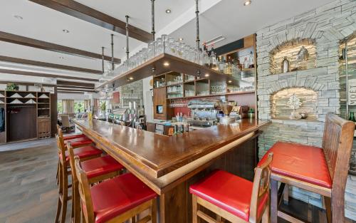 a bar with red seats at a restaurant at Landhotel Berger in Eben im Pongau