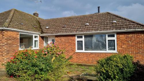 a brick house with a window and a roof at Certa Cito in Heacham