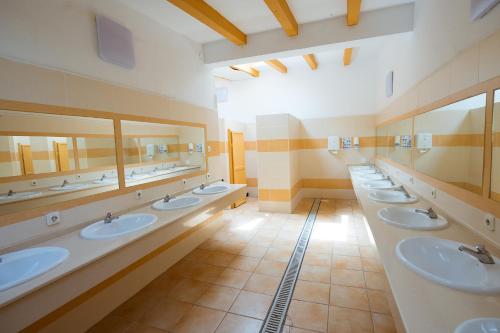 Baño con una fila de lavabos y espejos en Kampaoh Paloma en Tarifa