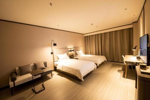 Łóżko lub łóżka w pokoju w obiekcie Hanting Hotel ining Taibai Hu Jinghang Road