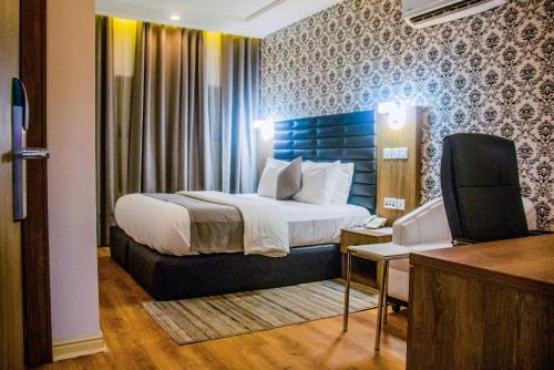 um quarto de hotel com uma cama e uma secretária em Crownsville Hotel - Airport Road em Port Harcourt