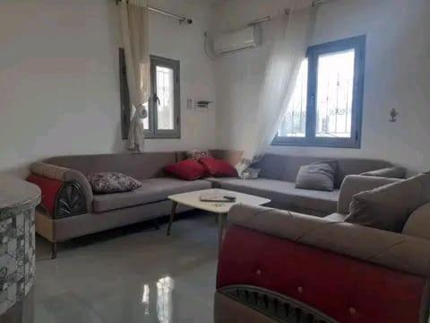 appartement douha Midoun في ميدون: غرفة معيشة مع كنبتين وطاولة