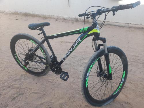 Una bicicleta estacionada en la arena de la playa en appartement douha Midoun en Midoun