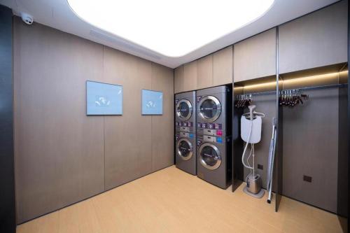 een wasruimte met 3 wasmachines in een ruimte bij Ji Hotel Jinan East Railway Station in Licheng