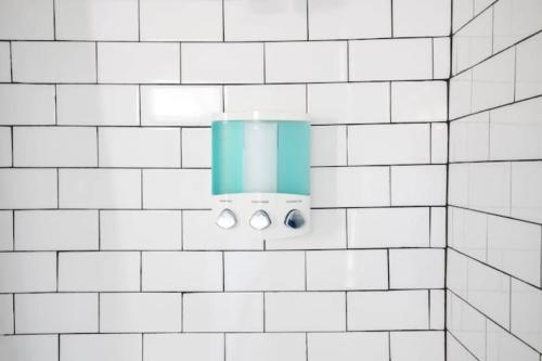 a bathroom with white tiled walls and a light fixture at East Lake Update-Close to Dining, 10min to Airport in Birmingham