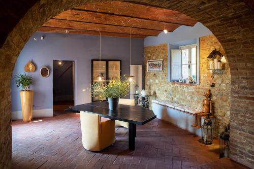 uma sala de jantar com uma mesa e uma parede de tijolos em Villa Alma - Homelike Villas em Montelupo Fiorentino