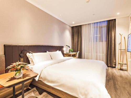 Säng eller sängar i ett rum på Hanting Premium Hotel Jinan Jiyang Jibei Park