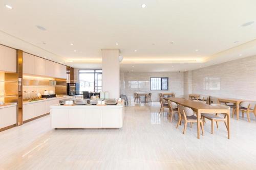 a kitchen and dining room with a table and chairs at Ji Hotel Quanzhou Jinjiang International Airport in Jinjiang