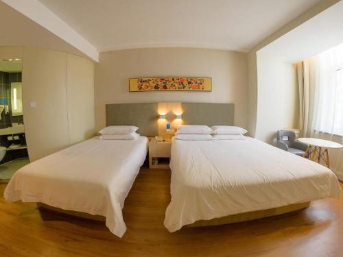 Säng eller sängar i ett rum på Hanting Hotel Jilin Jiangbei Park