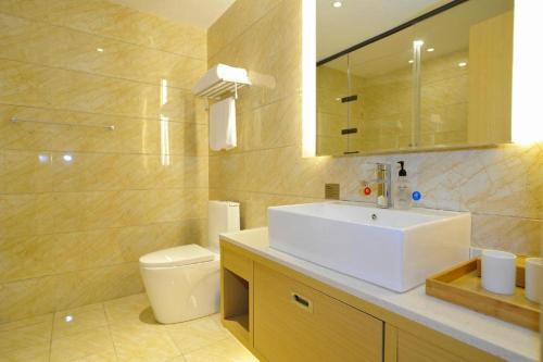 a bathroom with a white sink and a toilet at Starway Hotel Guiyang Big Cross in Guiyang