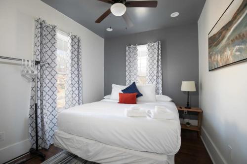 a bedroom with a white bed with a ceiling fan at Magic on 17th Street- Historic, Close to UAB, UAB Hospital in Birmingham