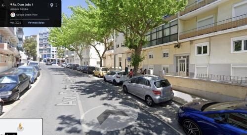a street with cars parked on the side of the road at Canto da Rocha Guesthouse in Almada