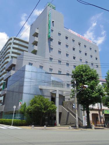 a large building with a reflection of a building at 南福岡グリーンホテル-Minami Fukuoka Green Hotel in Fukuoka