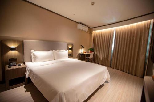 A bed or beds in a room at Hanting Hotel Pingdingshan Ruzhou
