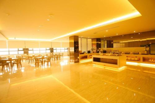 Habitación grande con mesas y sillas en un edificio en JI Hotel Kaifeng Qingming Shanghe Garden Fuxing Avenue, en Kaifeng