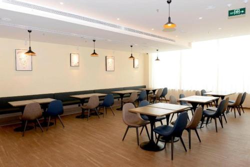 a restaurant with tables and chairs in a room at Hanting Hotel Heze Dingtao in Youji