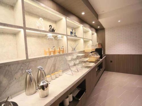 a kitchen with a counter with many items on it at Hanting Premium Hotel Donghai County Government in Donghai
