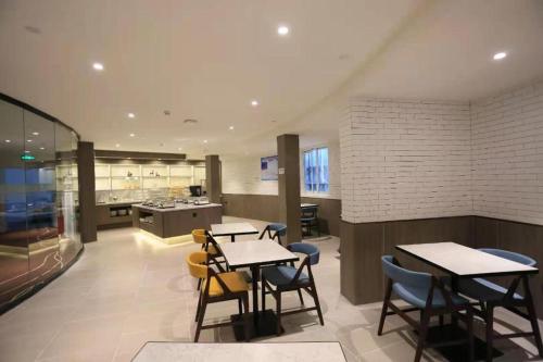 DonghaiにあるHanting Premium Hotel Donghai County Governmentのテーブルと椅子のあるレストラン、キッチンが備わります。