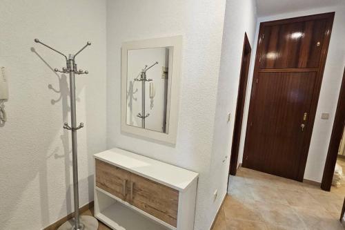 een witte badkamer met een wastafel en een spiegel bij Aloreña con balcones al Real in Úbeda