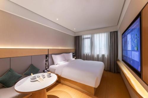 蘇州的住宿－Ji Hotel Suzhou Guanqian Street Ganjiang Xi Road，一间酒店客房,配有一张床和一台电视