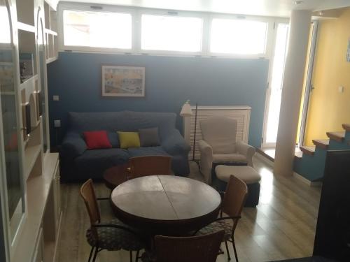 uma sala de estar com um sofá, uma mesa e cadeiras em Duplex entero con garaje privado y terraza em Albacete