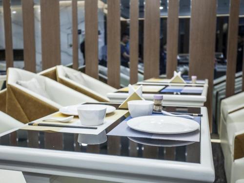 a table with plates and cups on a balcony at Starway Hotel Suqian Powerlong Plaza in Suqian