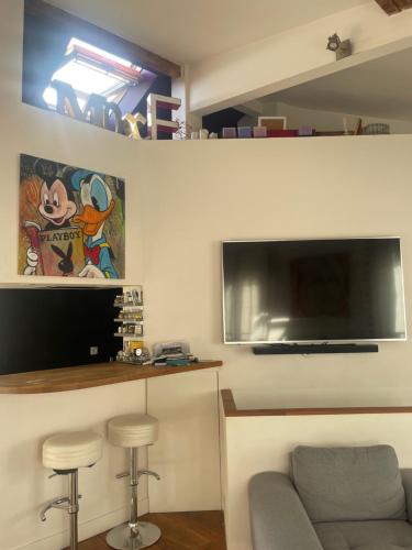 un salon avec un canapé et une télévision à écran plat dans l'établissement Un loft proche Bastille pour Paris 2024, à Paris