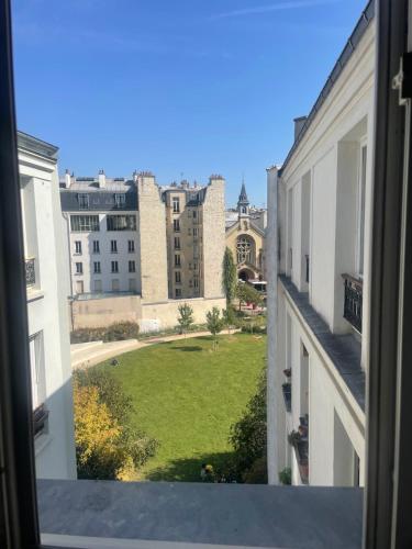 - une vue sur un champ verdoyant depuis une fenêtre dans l'établissement Un loft proche Bastille pour Paris 2024, à Paris