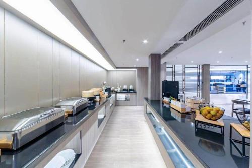 a large kitchen with a buffet line in a restaurant at Hanting Hotel Taicang Wanda Plaza in Taicang