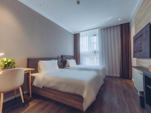 מיטה או מיטות בחדר ב-Hanting Premium Hotel Qingdao Yongping Road Metro Station