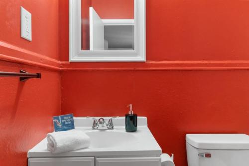 een badkamer met een wastafel en een rode muur bij The Bricks - Apt 1 in Birmingham