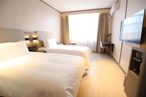 מיטה או מיטות בחדר ב-Hanting Hotel Hunchun Railway Station