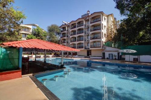 a large swimming pool in front of a building at BohoLush by Evanka in Vagator