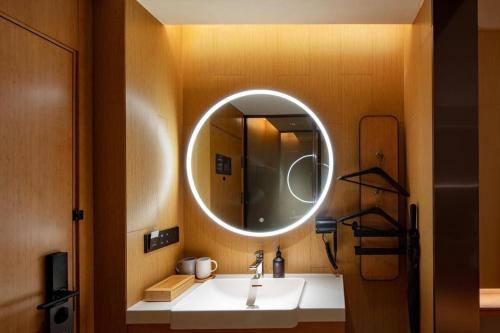 La salle de bains est pourvue d'un lavabo et d'un miroir. dans l'établissement Ji Hotel Guilin Two Rivers And Four Lakes Scenic, à Guilin
