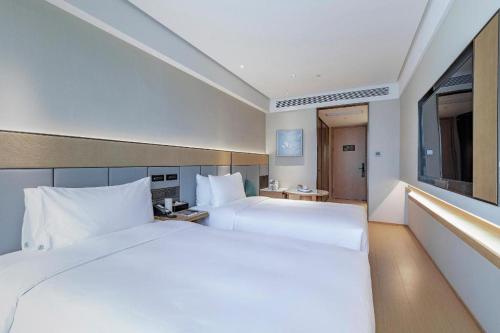 Łóżko lub łóżka w pokoju w obiekcie Ji Hotel Shanghai Pudong Airport Zhuqiao