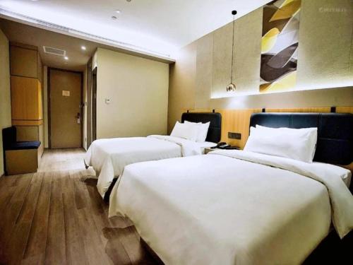 A bed or beds in a room at Hanting Premium Hotel Harbin Provincial Government