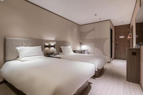 Hanting Hotel Xiamen Airport Chenggong Avenue房間的床