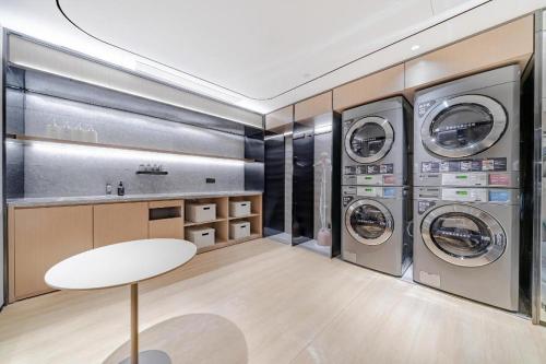 a laundry room with three washing machines and a table at Ji Hotel Tianjin Cultural Center in Yutai