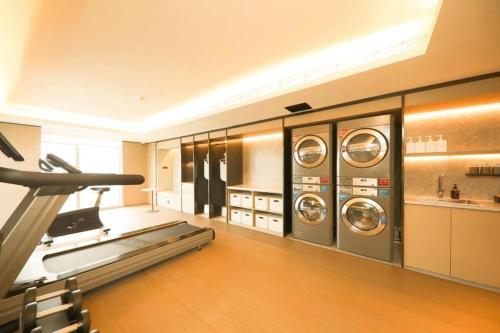 a laundry room with three washer and dryer machines at Ji Hotel Suqian Wanda Plaza in Suqian