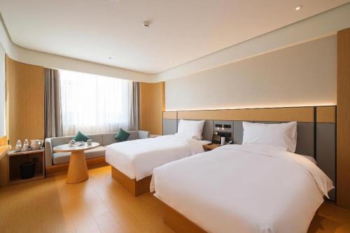 Un pat sau paturi într-o cameră la Ji Hotel Linfen Gulou South Street