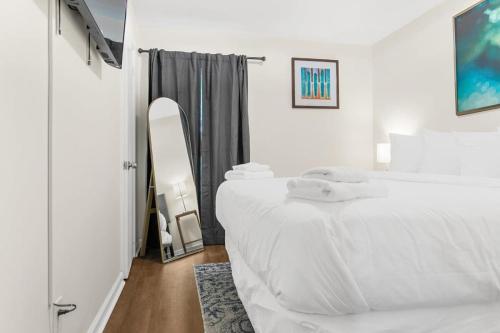 a white bedroom with a bed and a mirror at The Bricks - Apt 3 in Birmingham