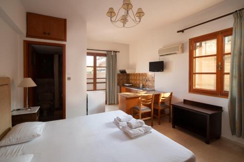 a bedroom with a bed and a desk and a kitchen at Alta Vista Studios - ex Lekka's House in Monemvasia
